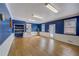Bonus room featuring hardwood floors, white wainscoting, bright blue walls and natural light at 202 Heights Pl, Canton, GA 30114