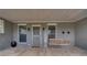 Charming front porch with hanging swing, brick flooring, and 