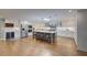 Spacious kitchen features a large island with seating, wine refrigerator, stainless steel appliances and hardwood floors at 202 Heights Pl, Canton, GA 30114