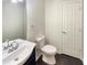 Updated bathroom with dark floors, white vanity, and toilet at 7045 Treeline Dr, Cumming, GA 30028