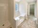 Bathroom with garden tub, shower, and updated flooring at 7045 Treeline Dr, Cumming, GA 30028