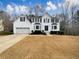 Two-story white house with a three-car garage and landscaped lawn at 7045 Treeline Dr, Cumming, GA 30028