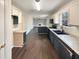 Open kitchen with dark wood flooring and stainless steel appliances at 7045 Treeline Dr, Cumming, GA 30028