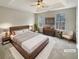 Virtually staged main bedroom with a large bed and ample natural light at 7045 Treeline Dr, Cumming, GA 30028