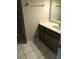 Bathroom featuring a vanity with white marble top, taupe cabinets, towel rack, and white tiled floors at 288 Heathersett Sw Dr, Marietta, GA 30064