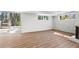 Unfurnished basement featuring a walkout to an outdoor patio area, white brick walls, and hardwood floors at 3732 Summitridge Dr, Atlanta, GA 30340