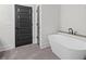 Bathroom featuring a standalone tub with stone surround and a black framed door at 130 West Lake Blvd, Carrollton, GA 30116