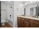 Bathroom with double vanity, wood cabinets, granite countertop, black hardware, and a shower tub at 130 West Lake Blvd, Carrollton, GA 30116