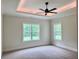 Bedroom with tray ceiling, ceiling fan, and large windows offering natural light and backyard views at 130 West Lake Blvd, Carrollton, GA 30116
