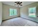 Bright bedroom with two large windows and neutral carpeting, complemented by a ceiling fan for added comfort at 130 West Lake Blvd, Carrollton, GA 30116
