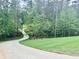 Long, winding driveway leading to the house, surrounded by mature trees and well-kept lawns at 130 West Lake Blvd, Carrollton, GA 30116