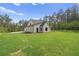 New construction home with a well-manicured lawn and covered porch in a wooded area at 130 West Lake Blvd, Carrollton, GA 30116