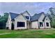 Low angle of the new construction home with traditional architecture, black shutters, neutral siding, and well-maintained lawn at 130 West Lake Blvd, Carrollton, GA 30116
