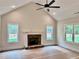 Bright living room features a stone fireplace, vaulted ceiling, recessed lighting, and large windows overlooking the yard at 130 West Lake Blvd, Carrollton, GA 30116