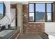 Beautiful bathroom with floating vanity, large window, subway tiles, and exposed brick accents with unique decor at 3235 Roswell Ne Rd # 617, Atlanta, GA 30305