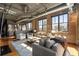 Open-concept living room with exposed brick and industrial-style ceiling leading into modern kitchen at 3235 Roswell Ne Rd # 617, Atlanta, GA 30305