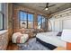 Spacious main bedroom with exposed brick, large windows, and stylish decor at 3235 Roswell Ne Rd # 617, Atlanta, GA 30305