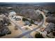 An aerial view shows the home nestled in a neighborhood with mature trees and nearby lake at 6310 Talking Tree Ct, Cumming, GA 30028