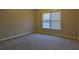 Neutral bedroom featuring soft carpeting, beige walls, and window with blinds at 6310 Talking Tree Ct, Cumming, GA 30028