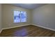 Bedroom with laminate floors and a window overlooking the neighborhood at 6310 Talking Tree Ct, Cumming, GA 30028