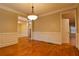 Elegant dining room featuring hardwood floors, wainscoting, and a stylish chandelier at 6310 Talking Tree Ct, Cumming, GA 30028