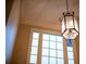 Close-up of a foyer chandelier, complemented by high ceilings and a large window at 6310 Talking Tree Ct, Cumming, GA 30028