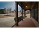 Covered front porch with wooden floors, framed by classic columns and dark shutters at 6310 Talking Tree Ct, Cumming, GA 30028
