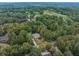 Beautiful aerial shot of a house nestled in a lush, green, wooded area near a golf course at 9070 Huntcliff Trce, Sandy Springs, GA 30350