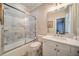 Bathroom featuring glass enclosed shower/tub, toilet, and a white vanity with countertop basin at 9070 Huntcliff Trce, Sandy Springs, GA 30350
