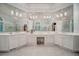 Bright bathroom featuring a dual sink vanity, large mirrors, marble floors, and modern lighting fixtures at 9070 Huntcliff Trce, Sandy Springs, GA 30350