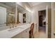 Bathroom with double sinks, large mirror and access to water closet and bedroom at 9070 Huntcliff Trce, Sandy Springs, GA 30350