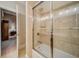 Bathroom featuring a tub with glass door and tiled walls at 9070 Huntcliff Trce, Sandy Springs, GA 30350
