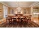 Formal dining room with elegant chandelier, table setting, and wainscoting at 9070 Huntcliff Trce, Sandy Springs, GA 30350