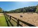 Outdoor equestrian arena with a sand surface, fenced perimeter, and various jump obstacles, perfect for riding at 9070 Huntcliff Trce, Sandy Springs, GA 30350