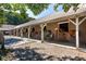 A horse barn exterior showcases multiple stalls in a ranch property on a sunny day at 9070 Huntcliff Trce, Sandy Springs, GA 30350