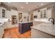 A stylish kitchen boasts white cabinets, a navy island, marble countertops, and stainless appliances at 9070 Huntcliff Trce, Sandy Springs, GA 30350