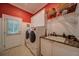 Laundry room with stacked washer and dryer, granite countertop, utility sink, and storage shelves at 9070 Huntcliff Trce, Sandy Springs, GA 30350