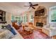 A cozy living room with stone fireplace and views to a beautiful outdoor setting at 9070 Huntcliff Trce, Sandy Springs, GA 30350