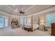 A spacious main bedroom features a sitting area, fireplace, and windows with plantation shutters at 9070 Huntcliff Trce, Sandy Springs, GA 30350