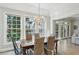 Light-filled dining room with a wooden table, wicker chairs, chandelier, and large windows overlooking the yard at 835 Springside Ne Ct, Atlanta, GA 30342