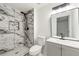 Beautifully remodeled bathroom with a new glass shower stall and modern fixtures and tiling at 1428 Muirfield Dr, Stone Mountain, GA 30088