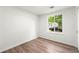 Sunlit bedroom featuring a large window, wood-look flooring, and neutral paint at 1428 Muirfield Dr, Stone Mountain, GA 30088