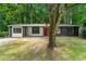 Charming one-story home with a brick and siding exterior, lush lawn and mature trees, perfect for nature lovers at 1428 Muirfield Dr, Stone Mountain, GA 30088