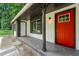 Inviting front porch with a bright red door and dark trim, offering a charming entrance to the home at 1428 Muirfield Dr, Stone Mountain, GA 30088