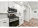 Updated kitchen featuring stainless steel appliances, white cabinets, and modern hardware at 1428 Muirfield Dr, Stone Mountain, GA 30088