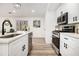 Bright kitchen with stainless steel appliances, white cabinets, and a view into the living area at 1428 Muirfield Dr, Stone Mountain, GA 30088