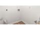 A view of an empty laundry room ready for appliances, with white walls and wood-look flooring at 1428 Muirfield Dr, Stone Mountain, GA 30088