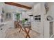 Eat-in kitchen featuring white cabinets, stainless steel appliances, brick backsplash, and wood beam accents at 6 Arden Moor Nw, Atlanta, GA 30305