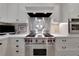 Close up view of stainless steel range top with white cabinetry in updated gourmet kitchen at 6 Arden Moor Nw, Atlanta, GA 30305