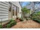 Cozy gravel patio with seating and French doors leading into home, surrounded by landscaped garden at 6 Arden Moor Nw, Atlanta, GA 30305
